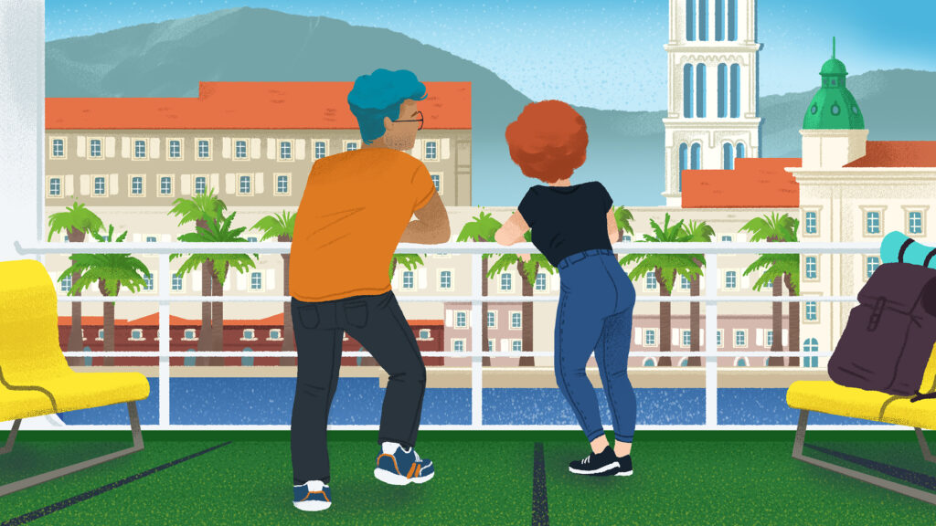 two people look out over a balcony at a view of a Croatian city